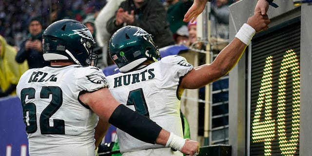 Philadelphia Eagles quarterback Jalen Hurts is congratulated by fans after he scored a touchdown against the New York Giants, Sunday, Dec. 11, 2022, in East Rutherford, New Jersey.