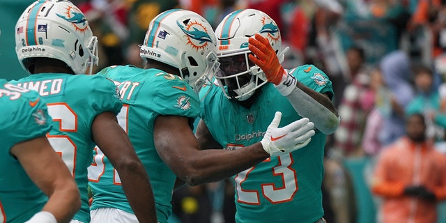 Miami Dolphins running back Jeff Wilson Jr. (23), celebrates with teammate Miami Dolphins running back Raheem Mostert (31) after scoring a touchdown during the first half of an NFL football game, Sunday, Dec. 25, 2022, in Miami Gardens, Fla.