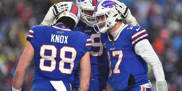 Buffalo Bills quarterback Josh Allen, right, celebrates his touchdown with tight end Dawson Knox and offensive tackle Spencer Brown during the second half, Sunday, Dec. 11, 2022, in Orchard Park, New York.