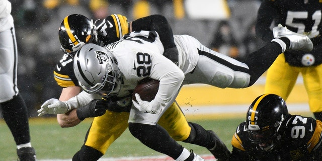 Las Vegas Raiders running back Josh Jacobs (28) is tackled by Pittsburgh Steelers linebacker Robert Spillane (41) during the first half of an NFL football game in Pittsburgh, Saturday, Dec. 24, 2022. 