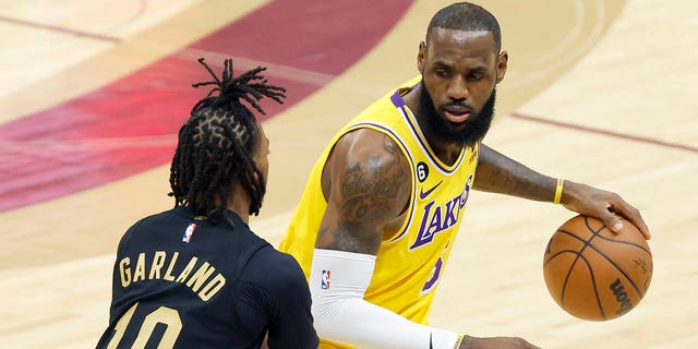 Los Angeles Lakers forward dLeBron James, right, is defended by Cleveland Cavaliers guard Darius Garland, #10, during the first half of an NBA basketball game Tuesday, Dec. 6, 2022, in Cleveland.