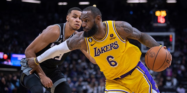 Los Angeles Lakers forward LeBron James, #6, drives past Sacramento Kings forward Keegan Murray, #13, during the second half in an NBA basketball game in Sacramento, California, Wednesday, Dec. 21, 2022.