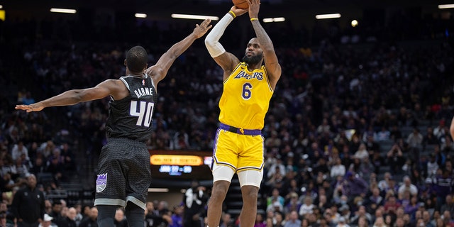 Los Angeles Lakers forward LeBron James, #6, shoots over Sacramento Kings forward Harrison Barnes, #40, during the second half in an NBA basketball game in Sacramento, California, Wednesday, Dec. 21, 2022. 