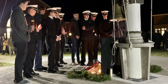 A group of Maine Maritime Academy students gather around a memorial set up on the school's Castine, Maine campus on Sunday, Dec. 11, to remember four students who died in a fiery weekend SUV crash.