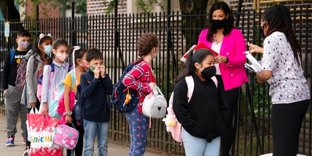 Teachers line up their students before entering the elementary school in the neighborhood.