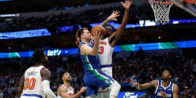 Luka Doncic of the Dallas Mavericks drives to the basket against Mitchell Robinson of the New York Knicks in the second half of their NBA game at American Airlines Center in Dallas on Tuesday.