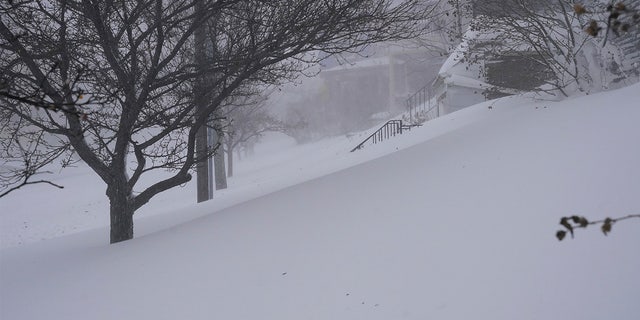 Snow drifts over the sidewalk on West Delavan Avenue in Buffalo, N.Y. on Saturday, Dec. 24, 2022.