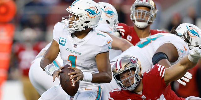 Miami Dolphins quarterback Tua Tagovailoa, #1, looks to pass before San Francisco 49ers defensive end Nick Bosa, #97, caused Tagovailoa to fumble, which 49ers linebacker Dre Greenlaw returned for a touchdown, during the second half of an NFL football game in Santa Clara, California, Sunday, Dec. 4, 2022. 