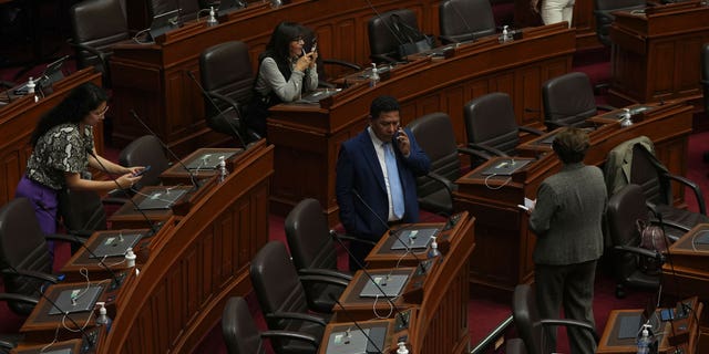 Lawmakers stand inside Congress on the day of their planned impeachment vote on President Pedro Castillo in Lima, Peru, Wednesday, Dec. 7, 2022. (AP Photo/Guadalupe Pardo)