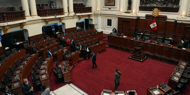 Lawmakers stand inside Congress on the day of their planned impeachment vote on President Pedro Castillo in Lima, Peru, Wednesday, Dec. 7, 2022. (AP Photo/Guadalupe Pardo)