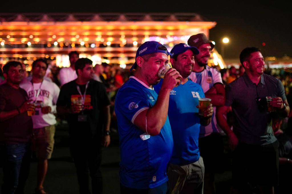 People drink beers as they watch in a giant screen at the fan zone the World Cup group A soccer match between Qatar and Ecuador being played at the Al Bayt stadium in Al Khor, in Doha, Qatar,