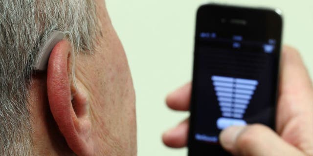 An employee of GN, the world's fourth-largest maker of hearing aids, demonstrates the use of ReSound LiNX in Vienna in November 2013. 