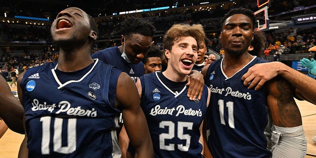 Saint Peter's players, from left, Fousseyni Drame, Doug Edert and KC Ndefo celebrate their win over Murray State Racers at Gainbridge Fieldhouse on March 19, 2022, in Indianapolis.