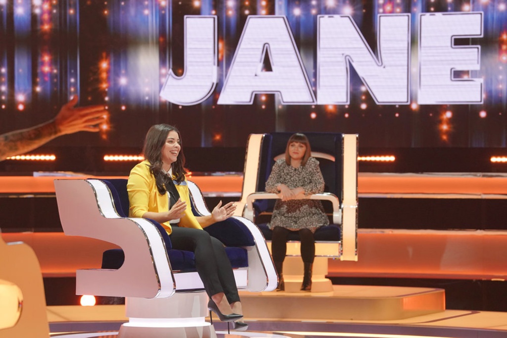 Photo of a contestant named Jane seated in her chair on "The Wheel" with celebrity Christina Ricci, who's in a chair alongside her, looking on. The name "JANE" is in capital letters across the top.