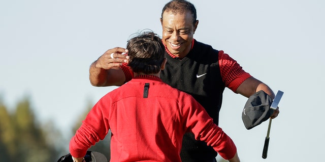 Tiger Woods, right, hugs his son Charlie Woods, left, after finishing the 18th hole during the final round of the PNC Championship golf tournament Sunday, Dec. 18, 2022, in Orlando, Florida.