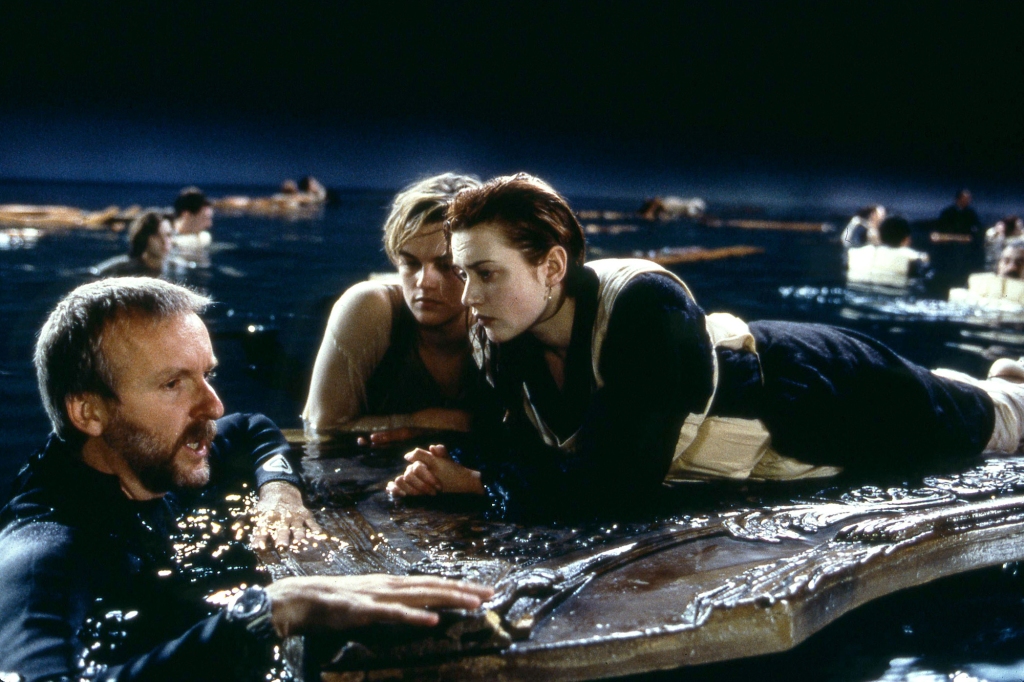 James Cameron with Leonardo DiCaprio and Kate Winslet filming "Titanic" in 1997. He's in the water, they are floating on the door. 