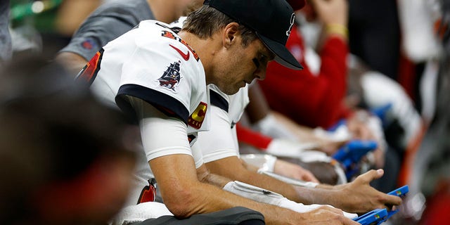 Tom Brady #12 of the Tampa Bay Buccaneers looks at a tablet during the game against the New Orleans Saints at Caesars Superdome on September 18, 2022 in New Orleans, Louisiana.