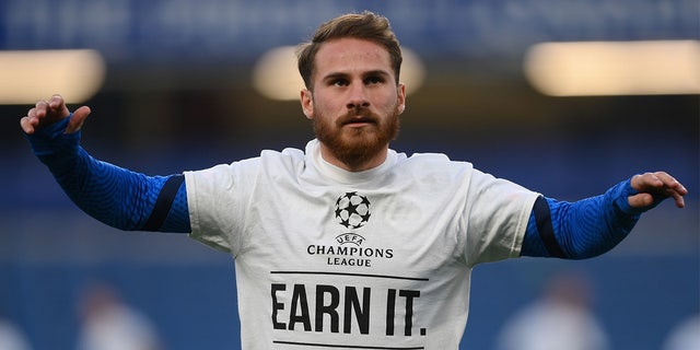 Alexis Mac Allister of Brighton and Hove Albion warms up wearing a T-shirt with a message in protest against the European Super League prior to a Premier League match against Chelsea at Stamford Bridge April 20, 2021, in London.