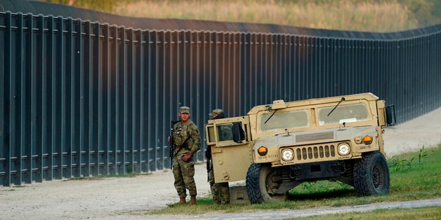 National Guardsmen stood watch near the International Bridge, where thousands of Haitian migrants created a makeshift camp, on Sept. 18, 2021, in Del Rio, Texas.