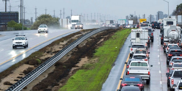 Cars are stopped in the northbound lanes of Highway 101 after flooding closed the highway near Chualar, California, Tuesday, Dec. 27, 2022.