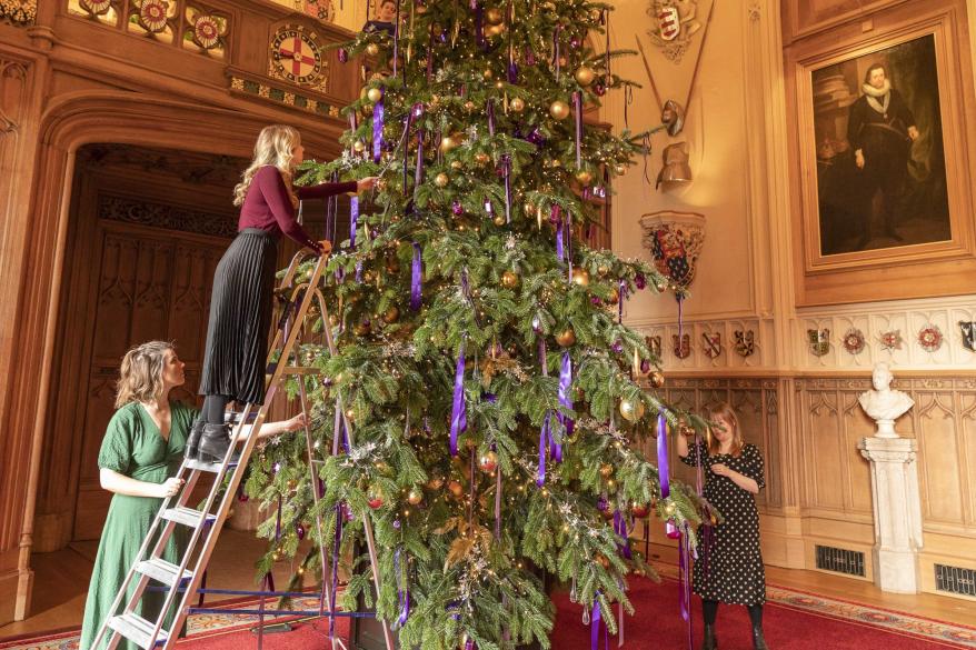 The 20-foot-high Nordmann Fir Christmas tree in St George's Hall. The tree, which is sourced from Windsor Great Park, took two full days to decorate with 3,000 lights, hundreds of iridescent jewel-shaped ornaments, and purple velvet and satin ribbons.