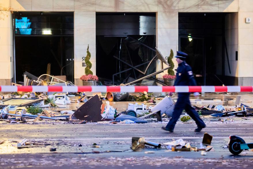 A police officer walks in front of debris after a huge aquarium burst at the Seal Life Aquarium in central Berlin, Germany, Friday, Dec. 16, 2022.