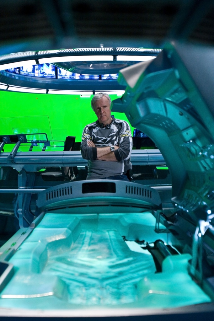 James Cameron on the set of "Avatar" in 2009 standing near a green screen and water tank. 