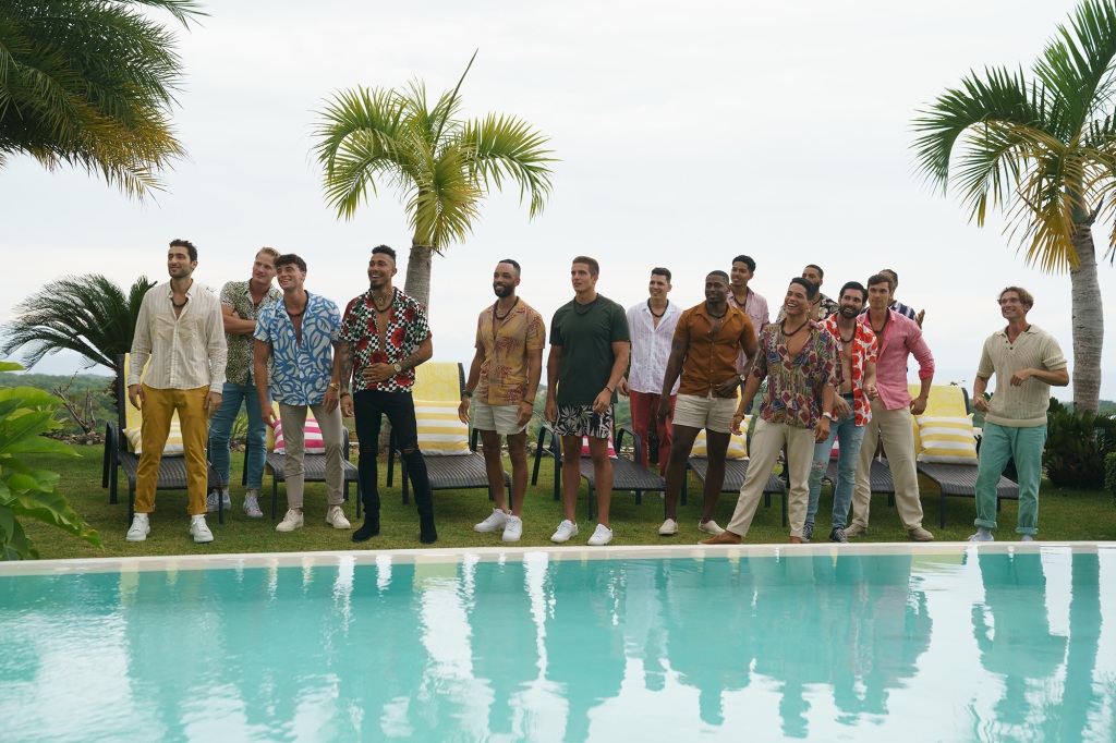 A group of men stand by a pool. 