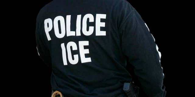 An Immigration and Customs Enforcement agent enters a restaurant to remove evidence in Cheektowaga, N.Y., April 16, 2008. 