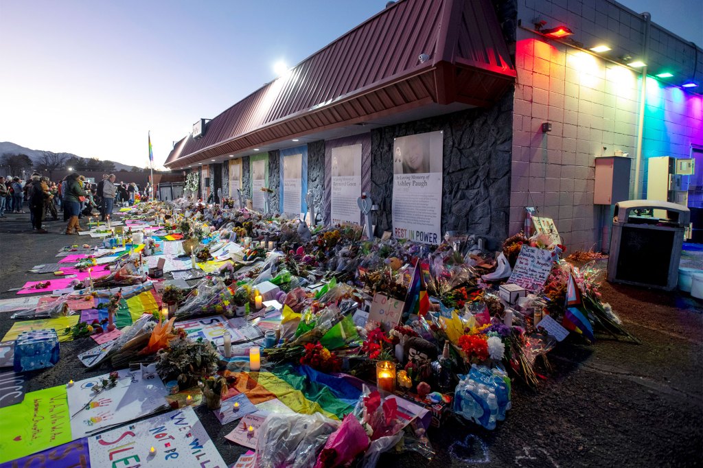 Mourners gather outside Club Q to visit a memorial, which has been moved from a sidewalk outside of police tape that was surrounding the club, on Nov. 25, 2022, in Colorado Spring, Colorado.