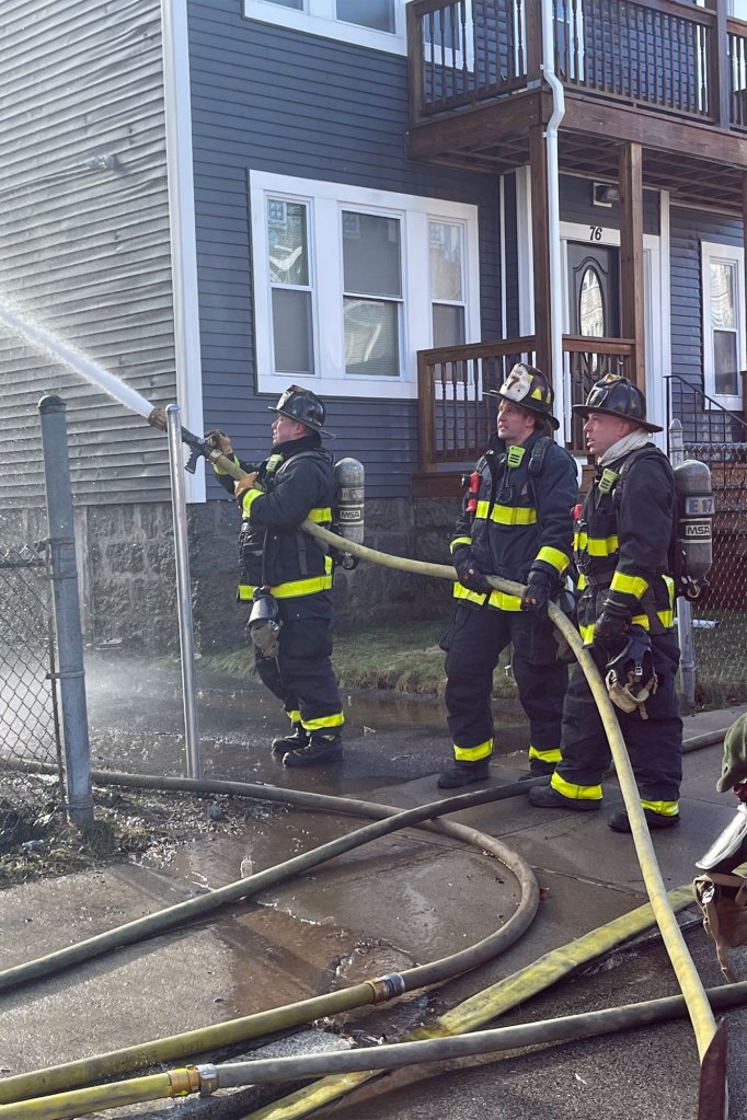 Fire crews work the three story wood frame home at 74 Mora Street in Dorchester on Dec, 26, 2022.