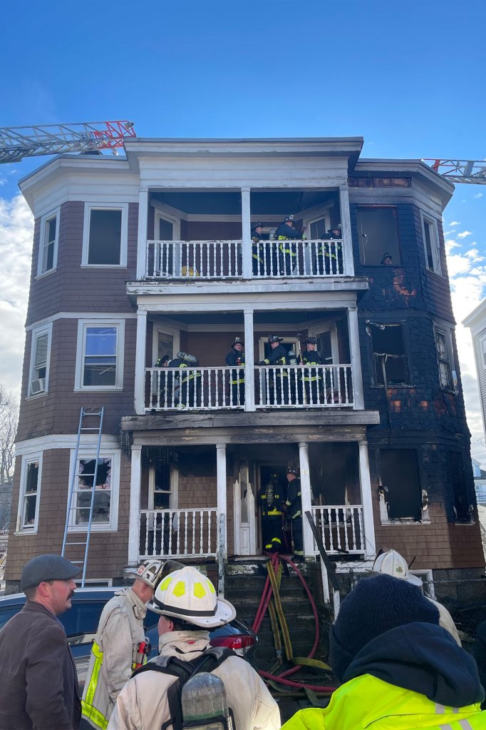 Firefighters work from separate balconies of the building after the blaze broke out from the first floor on Dec. 26, 2022.