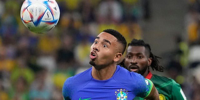 Brazil's Gabriel Jesus, front, and Cameroon's Andre-Frank Zambo Anguissa fight for the ball during a World Cup Group G game at Lusail Stadium in Lusail, Qatar, Friday, Dec. 2, 2022. 