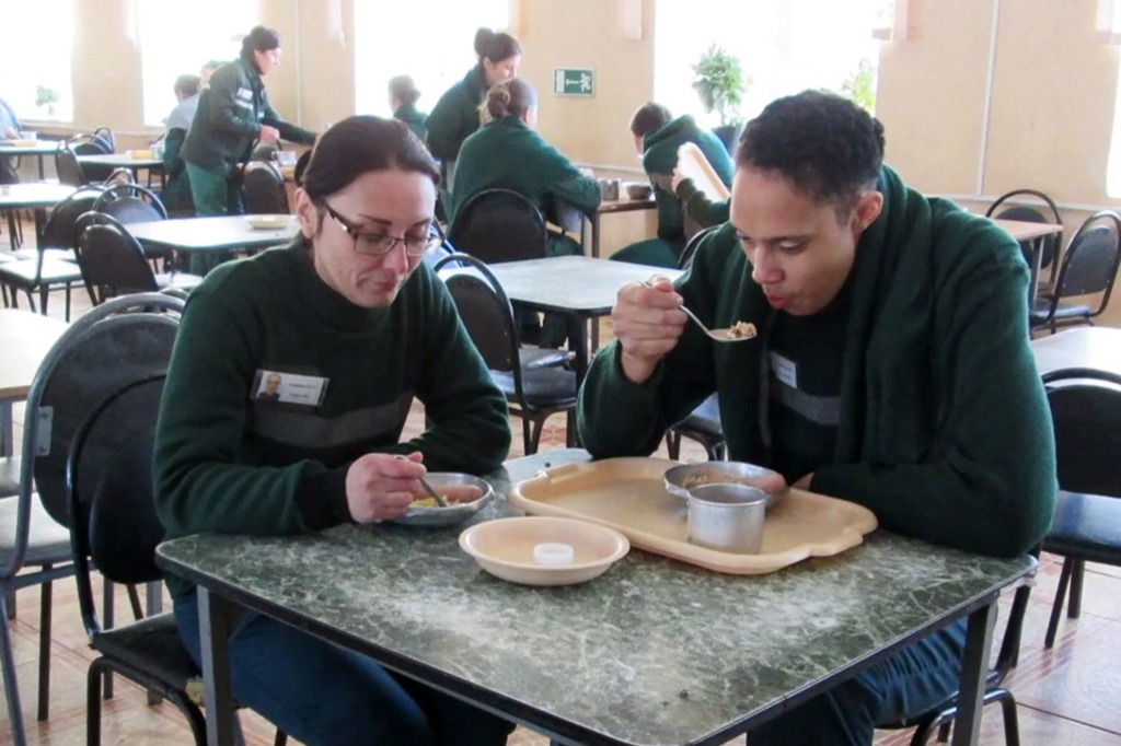 Griner seen sitting down to eat with another prisoner.