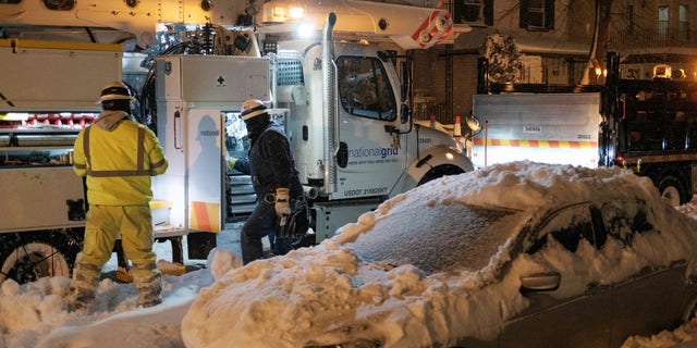 National Grid technicians work in Buffalo, New York, on December 26, 2022. - Emergency crews in New York were scrambling on December 26, 2022, to rescue marooned residents from what authorities called the "blizzard of the century," a relentless storm that has left at least 25 dead in the state and is causing US Christmas travel chaos. (Photo by Joed Viera / AFP) (Photo by JOED VIERA/AFP via Getty Images)