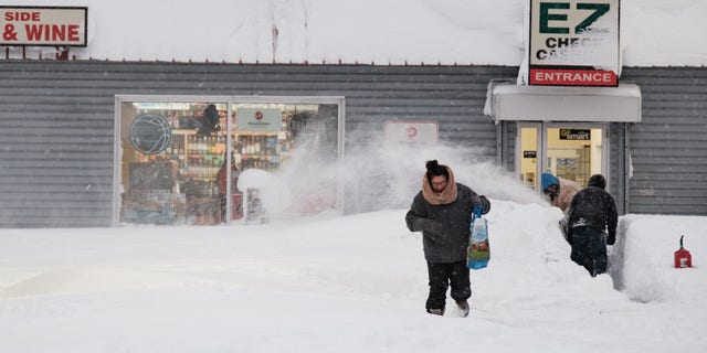 A resident leaves a local corner store in Buffalo, New York, on December 26, 2022, as many major grocery stores remained closed. - Emergency crews in New York were scrambling on December 26, 2022, to rescue marooned residents from what authorities called the "blizzard of the century," a relentless storm that has left at least 25 dead in the state and is causing US Christmas travel chaos. (Photo by Joed Viera / AFP) (Photo by JOED VIERA/AFP via Getty Images)