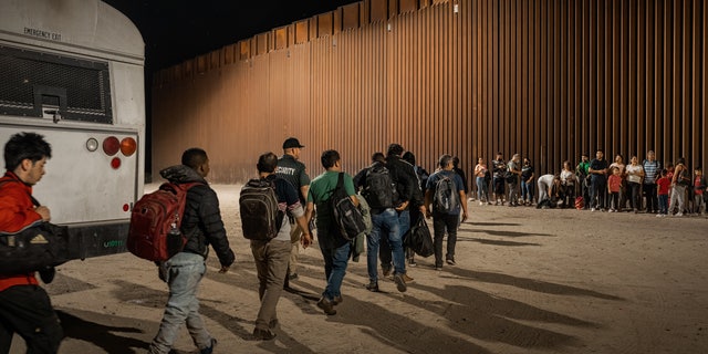 Immigrants wait to be processed by U.S. Border Patrol after crossing the border from Mexico, Aug. 6, 2022, in Yuma, Arizona.