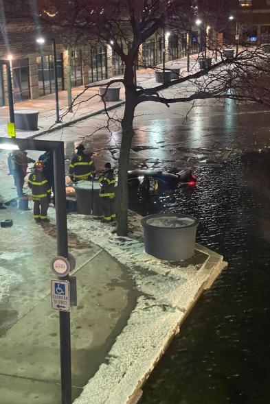 Firefighters respond to the car submerged in the canal's waters