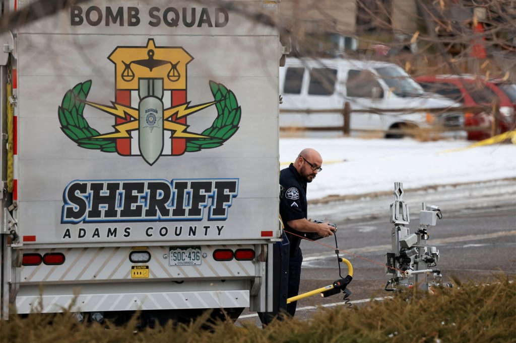 A member of the Adams County Sheriff's office works near the scene at a Jehovah's Witnesses Kingdom Hall in Thornton, Colo., on Dec. 25, 2022. 