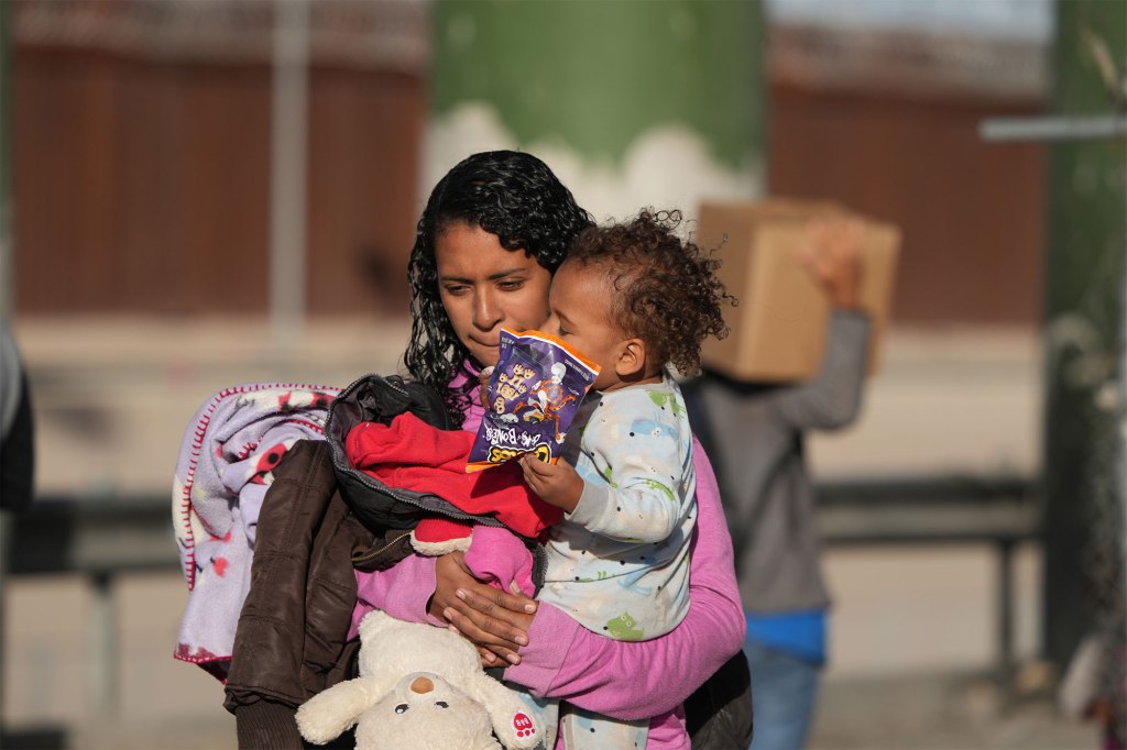 A mother holds her child while waiting at the Mexico-US border on December 27. 