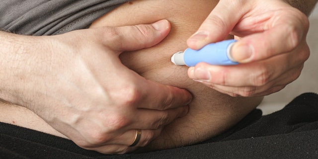 Man sticking himself with the Semaglutide Ozempic injection, a treatment for Type 2 Diabetes that is now also being used for weight loss.