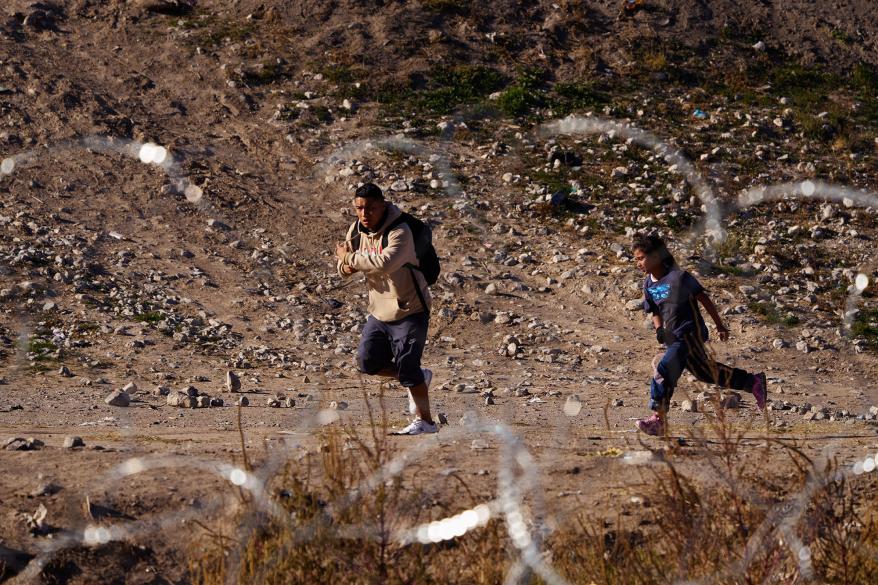 Migrants sprint towards a border entry point at the border.