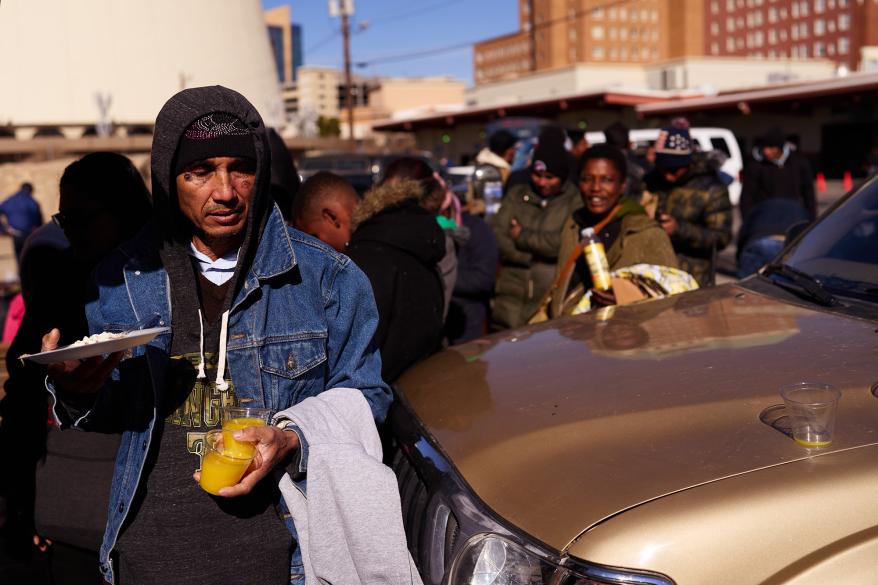 Migrants receive donated meals near a Grayhound bus station on Dec. 17, 2022 in El Paso, Texas.