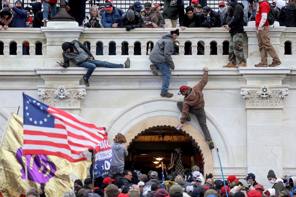 A mob of supporters of Donald Trump fight with members of law enforcement at a door they broke open as they storm the Capitol Building in Washington, DC on Jan. 6, 2021.