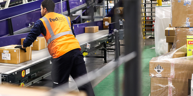 FedEx hub staff sort parcels.