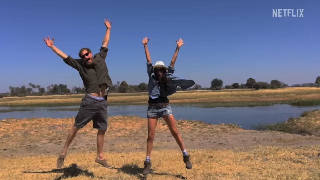 Prince Harry and Meghan Markle jumping on a beach. 