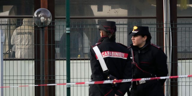 Italian Carabinieri patrol in front of a bar where three people died after a man entered and shot in Rome, Sunday, Dec. 11, 2022. 