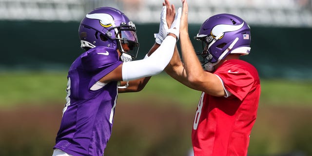 Justin Jefferson, left, and Kirk Cousins of the Minnesota Vikings high-five during a joint practice with the San Francisco 49ers at training camp at TCO Performance Center Aug. 18, 2022, in Eagan, Minn.