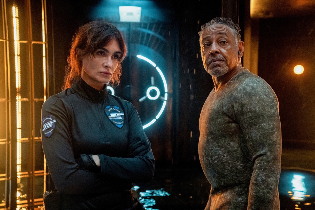 Paz Vega as Ava Mercer, Giancarlo Esposito as Leo Pap in "Kaleidoscope" standing by a vault. 