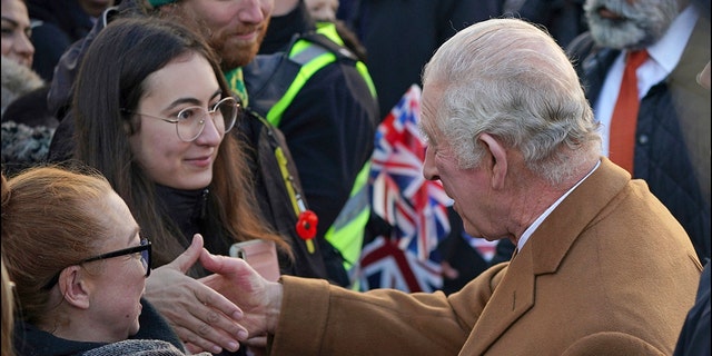 Britain's King Charles III, right, greets members of the public as he arrives for a visit to Luton Town Hall, where he is meeting community leaders and voluntary organizations, in Luton, England, Tuesday, Dec. 6, 2022. 